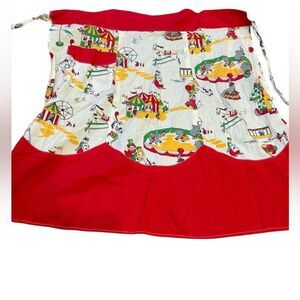 vintage half-apron with a circus-themed pattern on the top and solid red bottom